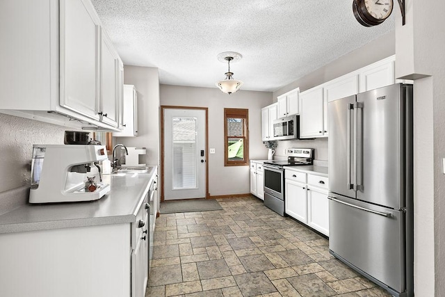 681 4th St NE, Little Falls, MN 56345 - kitchen featuring stainless steel appliances, a sink, white cabinetry, light countertops, and a textured ceiling
