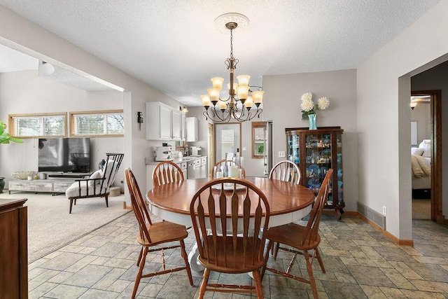 681 4th St NE, Little Falls, MN 56345 - dining area with stone tile flooring, a chandelier, a textured ceiling, and baseboards