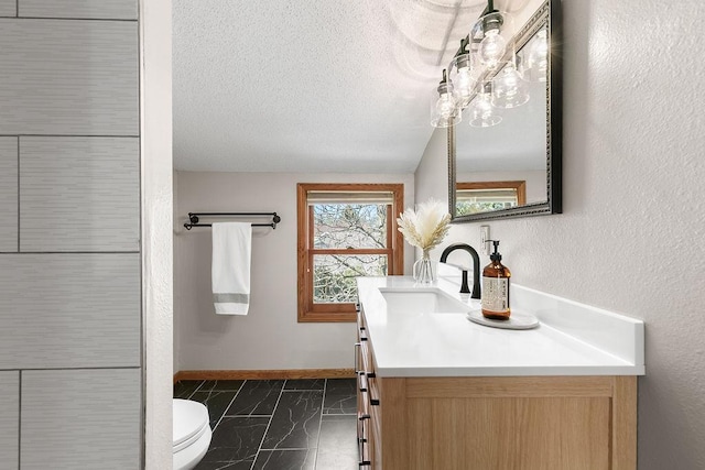 681 4th St NE, Little Falls, MN 56345 - bathroom with vanity, baseboards, marble look tiles, toilet, and a textured ceiling