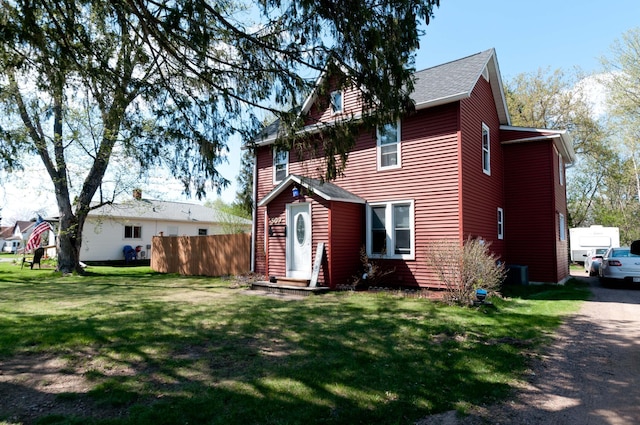 back of property featuring a yard and central AC