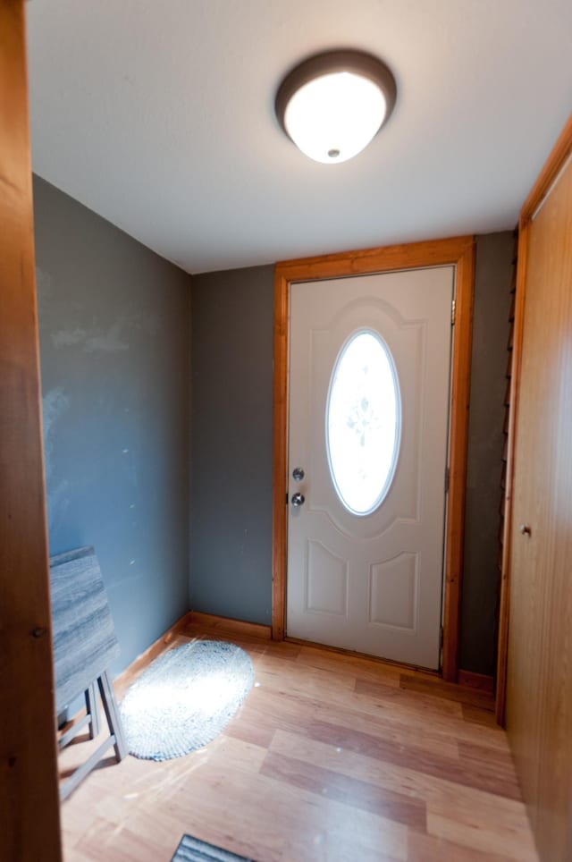 foyer with light wood-style flooring and baseboards