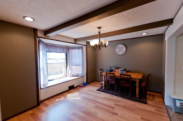 dining room with beam ceiling, a chandelier, light wood finished floors, recessed lighting, and a textured ceiling