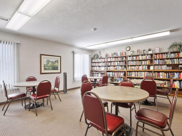7520 Cahill Rd Unit 222A, Edina, MN 55439 - dining area with light colored carpet, a textured ceiling, and baseboards