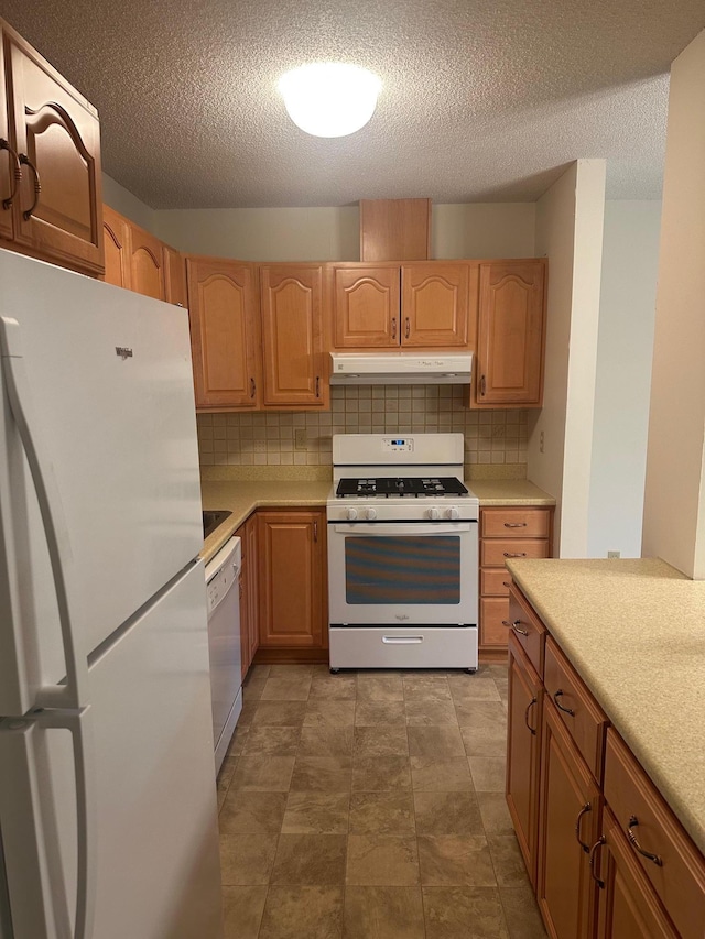 7520 Cahill Rd Unit 222A, Edina, MN 55439 - kitchen with white appliances, under cabinet range hood, light countertops, backsplash, and a textured ceiling