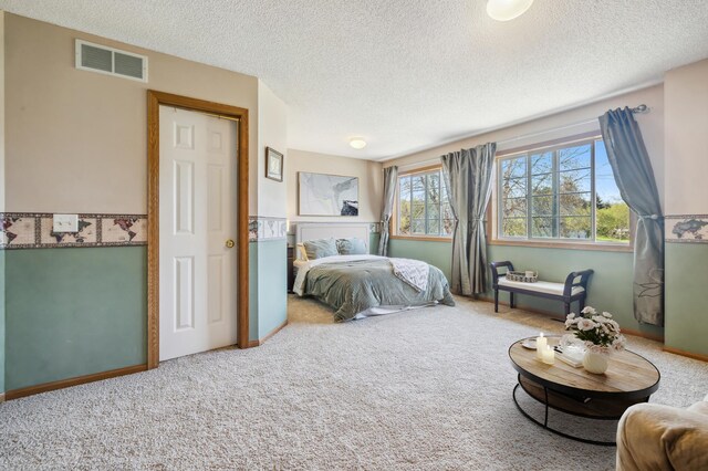 bedroom featuring carpet flooring, a textured ceiling, and baseboards