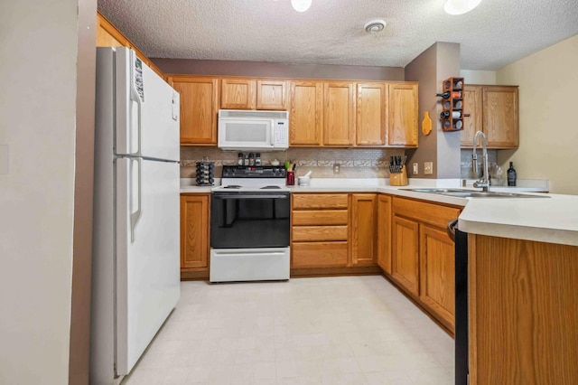 kitchen with white appliances, a sink, light countertops, a peninsula, and tasteful backsplash