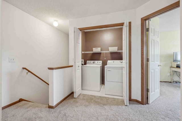washroom with washing machine and dryer, carpet, and baseboards