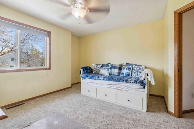 carpeted bedroom featuring baseboards and a ceiling fan