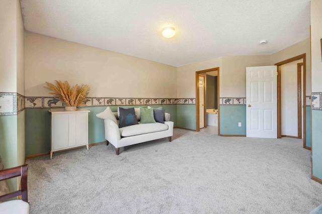 sitting room with a textured ceiling, carpet floors, and baseboards