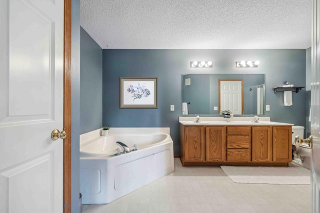 bathroom with a garden tub, a textured ceiling, double vanity, and a shower with shower door
