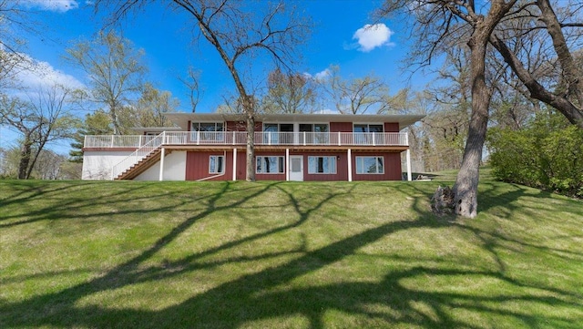 back of property with stairway, a yard, and a deck