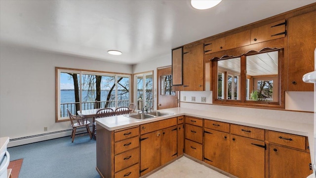 kitchen featuring a baseboard radiator, a sink, light countertops, and brown cabinetry