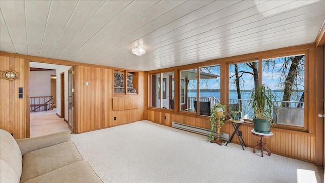 living area featuring baseboard heating, carpet, wooden walls, a water view, and wood ceiling