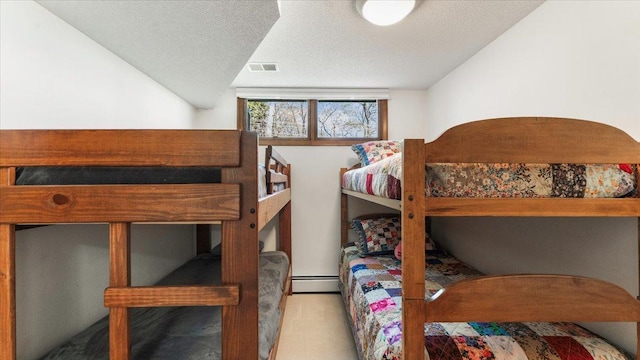 bedroom featuring a baseboard radiator and a textured ceiling