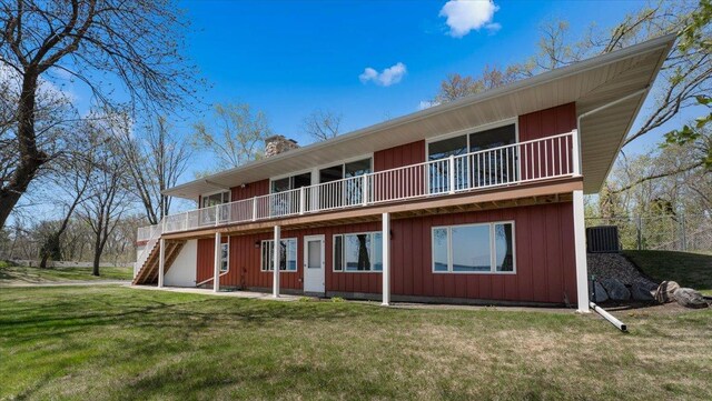 rear view of house with a chimney, stairway, a wooden deck, central air condition unit, and board and batten siding