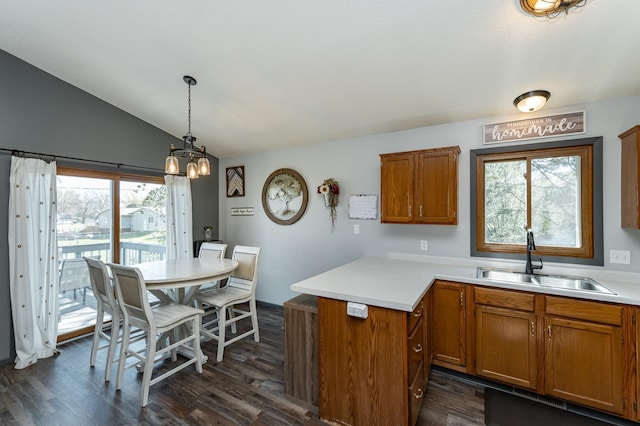 192 Harrison Ave SE, Racine, MN 55967 - kitchen with a sink, brown cabinets, a peninsula, lofted ceiling, and light countertops