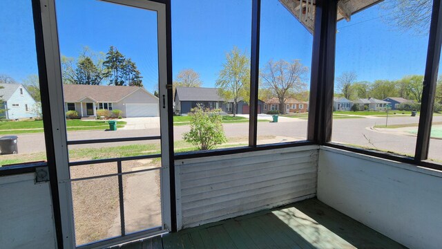 unfurnished sunroom with healthy amount of natural light and a residential view