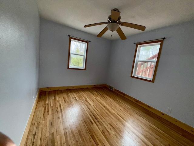 unfurnished room with light wood-style flooring, baseboards, and a ceiling fan