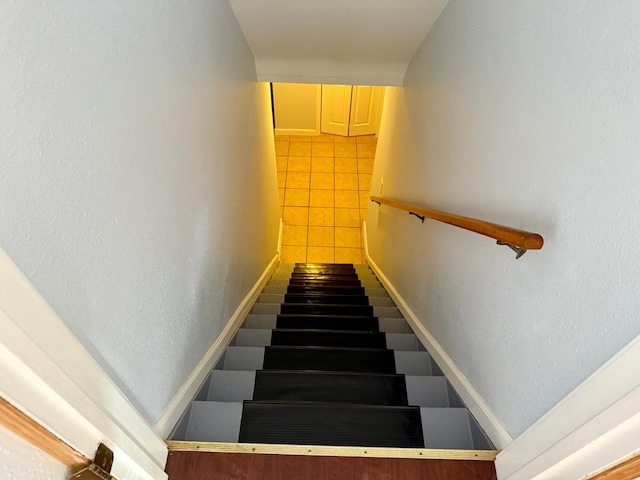 stairway featuring tile patterned flooring