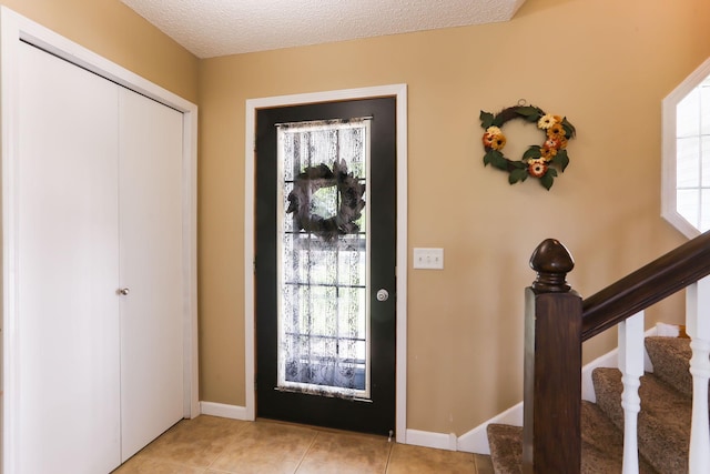 18071 Lincoln Cir NW, Elk River, MN 55330 - foyer with stairway, baseboards, a textured ceiling, and light tile patterned floors