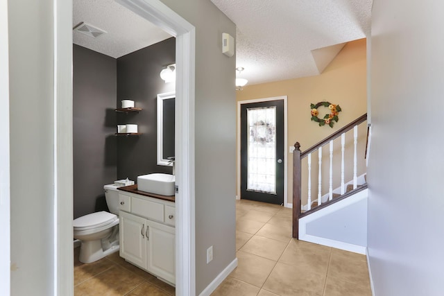 18071 Lincoln Cir NW, Elk River, MN 55330 - bathroom featuring a textured ceiling, tile patterned flooring, vanity, toilet, and baseboards