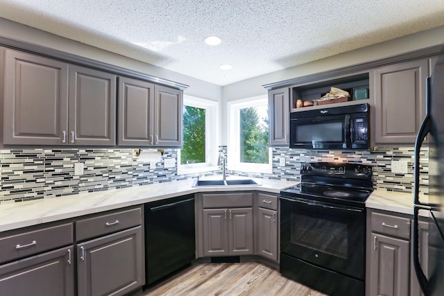 18071 Lincoln Cir NW, Elk River, MN 55330 - kitchen with black appliances, gray cabinetry, a sink, light wood finished floors, and light countertops