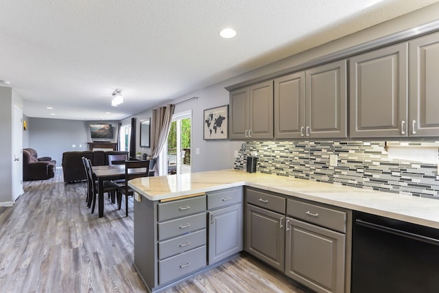 18071 Lincoln Cir NW, Elk River, MN 55330 - kitchen with gray cabinetry, a peninsula, tasteful backsplash, light wood-style flooring, and a textured ceiling