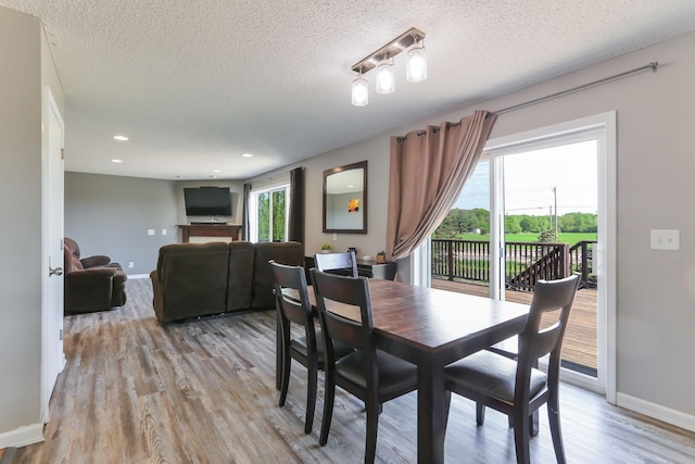 18071 Lincoln Cir NW, Elk River, MN 55330 - dining area featuring a textured ceiling, light wood finished floors, baseboards, and recessed lighting