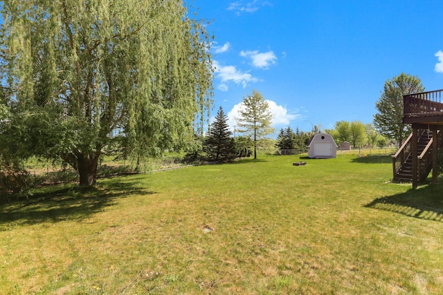 18071 Lincoln Cir NW, Elk River, MN 55330 - view of grassy yard featuring stairs, a shed, an outdoor structure, and a deck