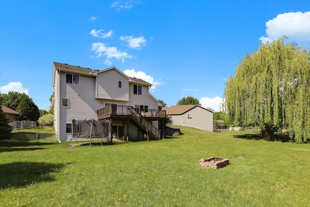18071 Lincoln Cir NW, Elk River, MN 55330 - back of house featuring stairs, a wooden deck, and a trampoline