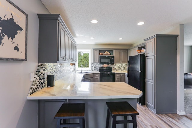 18071 Lincoln Cir NW, Elk River, MN 55330 - kitchen with black appliances, open shelves, a sink, a peninsula, and gray cabinetry