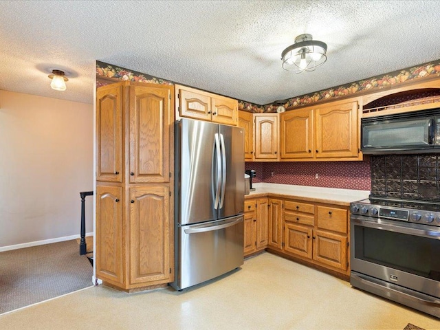 19531 Pine Landing Dr, Grand Rapids, MN 55744 - kitchen featuring stainless steel appliances, a textured ceiling, light countertops, brown cabinets, and tasteful backsplash