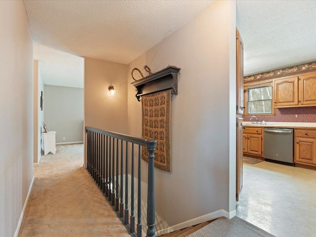 19531 Pine Landing Dr, Grand Rapids, MN 55744 - hallway with a textured ceiling, light carpet, an upstairs landing, baseboards, and a sink