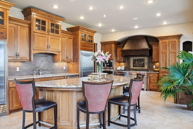 1860 Shoreline Dr, Orono, MN 55391 - kitchen with appliances with stainless steel finishes, recessed lighting, brown cabinets, premium range hood, and a center island