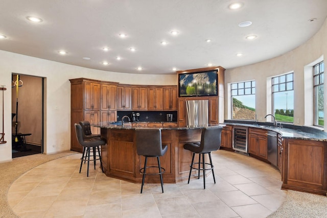 1860 Shoreline Dr, Orono, MN 55391 - kitchen featuring beverage cooler, appliances with stainless steel finishes, a spacious island, brown cabinetry, and recessed lighting