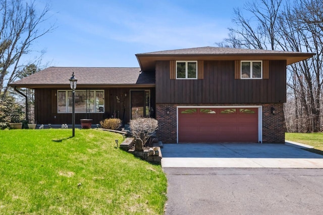 split level home with a front lawn, brick siding, an attached garage, and aphalt driveway