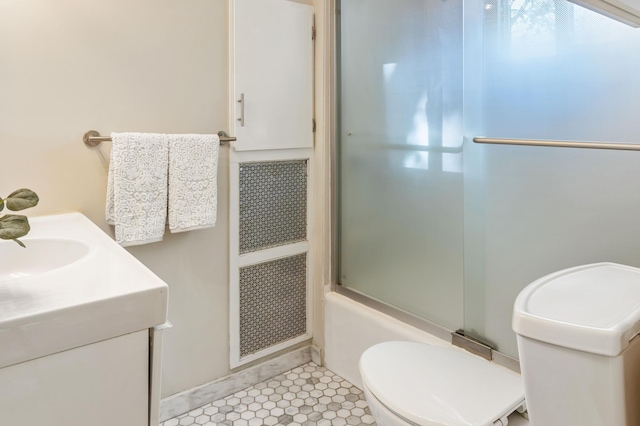 bathroom with toilet, vanity, and tile patterned flooring