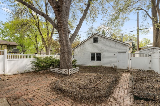 back of house featuring a gate, a fenced backyard, and a patio area