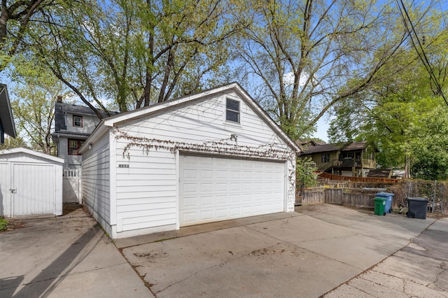 detached garage featuring fence