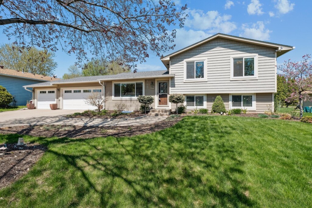 1709 Monticello Ave, Eagan, MN 55122 - tri-level home with an attached garage, concrete driveway, a front yard, and entry steps