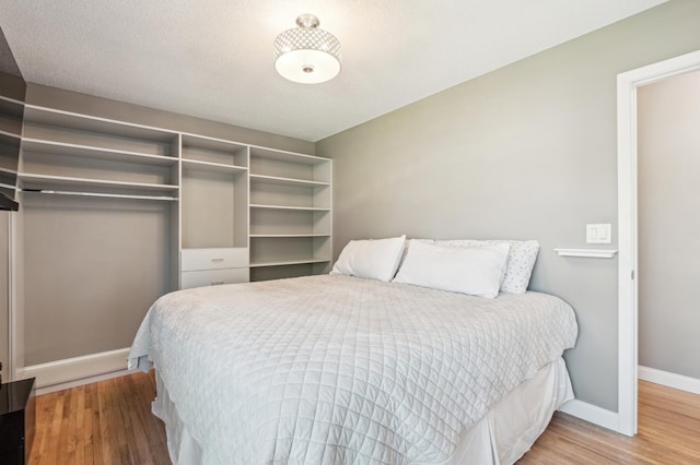 bedroom with wood finished floors and baseboards