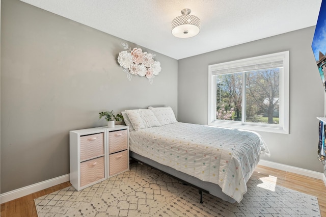 bedroom with baseboards and light wood-type flooring