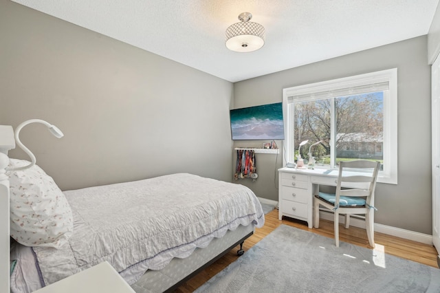 bedroom featuring wood finished floors and baseboards