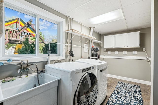 laundry room with washing machine and clothes dryer, cabinet space, and baseboards