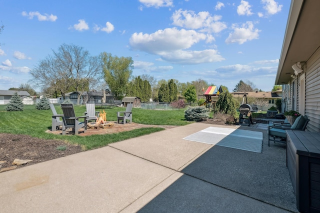 view of patio featuring a playground, grilling area, and an outdoor living space with a fire pit