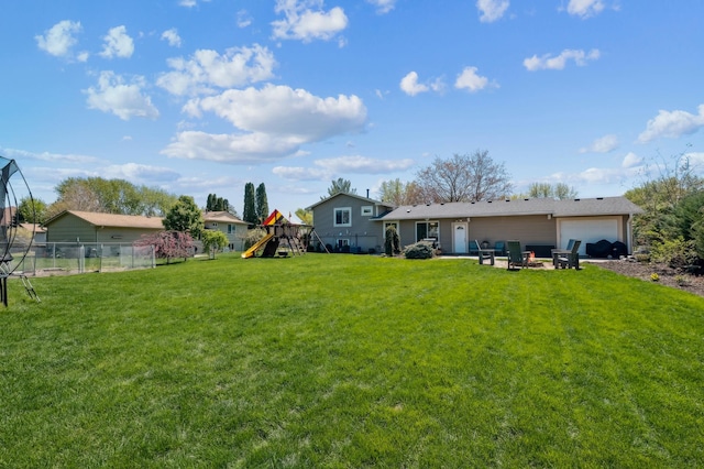 rear view of property featuring a playground and a garage