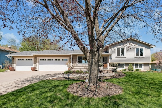 tri-level home with driveway, an attached garage, and a front yard