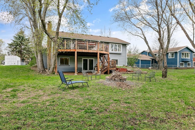 rear view of property featuring a deck, stairs, a chimney, and a fire pit