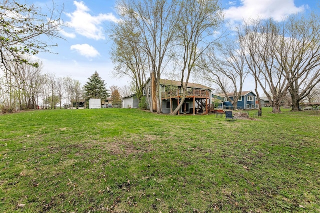 view of grassy yard featuring a deck and stairway