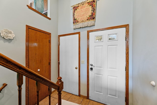 foyer entrance featuring light tile patterned flooring and stairway